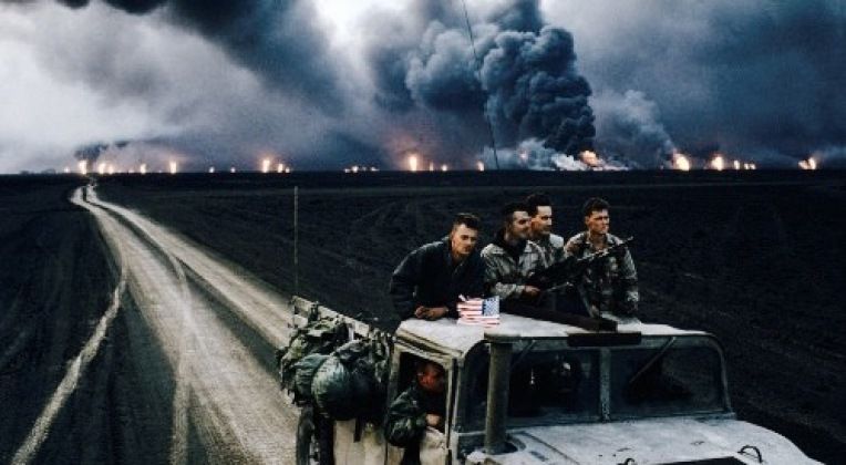U.S. Soldiers Drive Away From Burning Oil Field